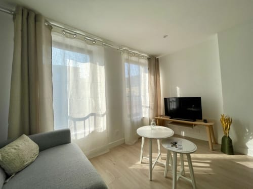Élégant séjour moderne à Mattbnb Metz avec canapé, téléviseur, tables rondes et vue panoramique sur la ville