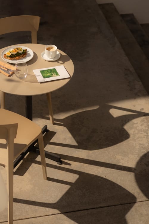 Sunny outdoor table at Hotel Fragile in Ciutadella de Menorca with breakfast plate, coffee, and Mediterranean views