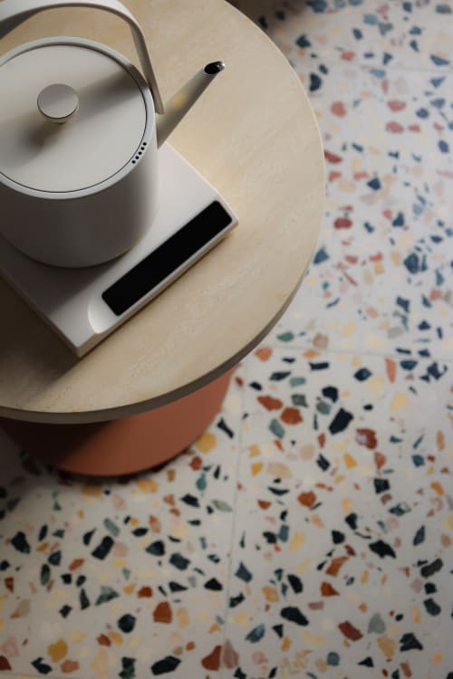 White kettle and amenities on wooden table with colorful terrazzo flooring at Hotel Fragile, Menorca