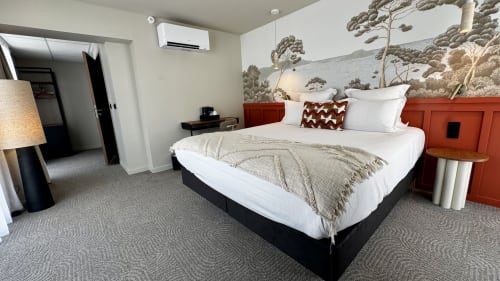 Chambre moderne de l'Hôtel des Quatre Saisons à Guérande avec lit king-size, tête de lit rouge, fresque paysagère et accessible