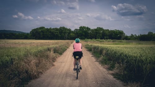 Cycliste sur un chemin de terre rustique à travers les champs près de La Grange Aux Etangs, Sennely, France