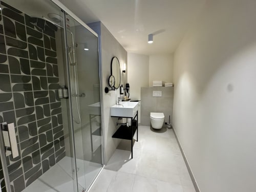Salle de bains moderne à l'Hôtel des Quatre Saisons Guérande avec douche à l'italienne, carrelage géométrique, vasque blanche et toilettes