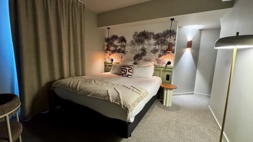 Chambre king-size moderne à l'Hôtel des Quatre Saisons de Guérande avec fresque forestière, luminaires suspendus et design contemporain