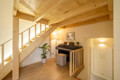 Interior moderno do apartamento AgapeStay Porto com vigas de madeira, piano, escada e pisos em madeira em Porto, Portugal