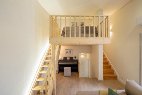 Apartamento estilo loft em AgapeStay Porto com quarto no mezanino, piano, assoalho em madeira e espaço de estar moderno