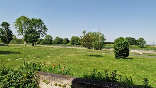 Les jardins pittoresques au bord de la rivière de l'Hôtel Rose à Beauvoir avec pelouses verdoyantes, arbres et plantations florales
