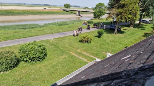 Vue aérienne des jardins riverains de l'Hôtel Rose à Beauvoir avec pelouse soignée, allée et paysage bordé d'arbres