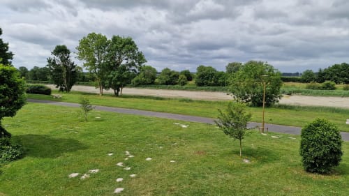 Jardin soigné de l'Hôtel Rose Beauvoir avec allée riveraine, pelouse verdoyante, arbres matures et vues sur l'eau