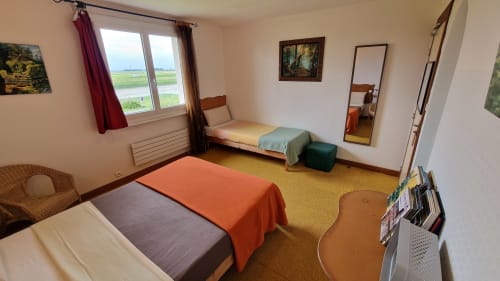 Chambre triple avec vue sur la rivière à l'Hôtel Rose à Beauvoir, avec deux lits et salle de bains avec baignoire