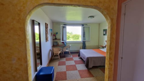 Spacieuse chambre triple à l'Hôtel Rose avec vue sur rivière, sol en damier, bureau, lit et lumière naturelle