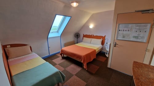 Deux lits dans une chambre communicante avec vue sur la rivière à l'Hôtel Rose de Beauvoir, équipée de puits de lumière et d'équipements modernes