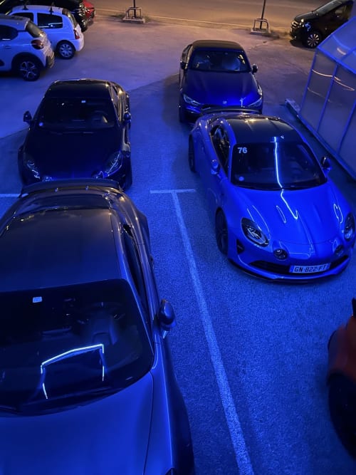 Parking de nuit à l'Hôtel Du Rocher au Caylar avec voitures de sport de luxe illuminées
