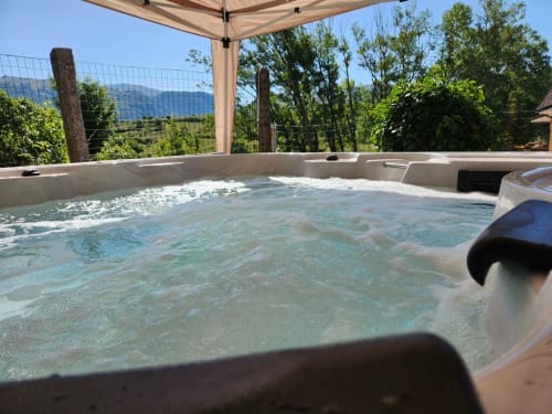 Vasca idromassaggio con vista sulle montagne sotto pergolato all'Antico Chalet Momosa a Ovindoli, Italia