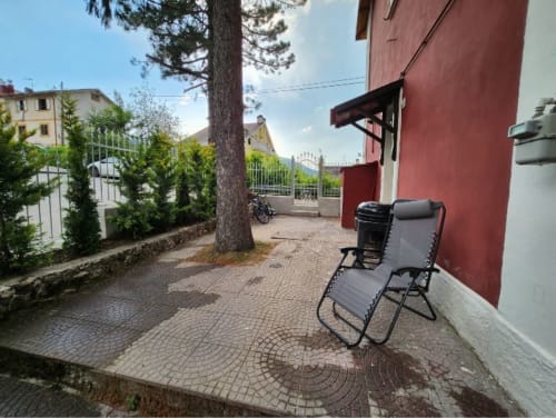 Zona patio dello Chalet Mini Mimosa a Ovindoli con sdraio, vista montagna e giardino lussureggiante