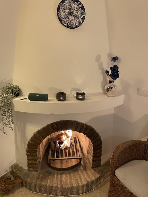 Chimenea de lujo con plato decorativo, flores y velas en Nerja Holiday Homes