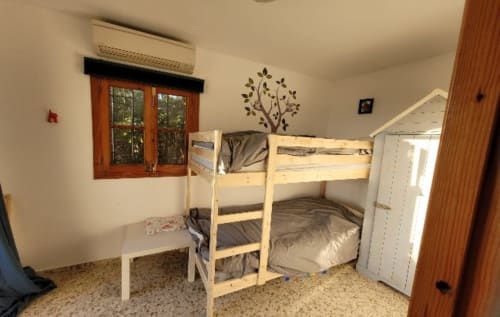 Dormitorio luminoso con litera de madera, escritorio blanco y ventana en apartamento Nerja Holiday Homes en España