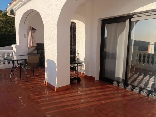 Soleada terraza con arcos blancos, azulejos de terracota y vistas al mar en apartamento de lujo Nerja Holiday Homes