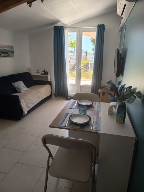 Modern cottage dining area at Pugetvilla with blue curtains, set table, and pool view doors in Puget-Ville