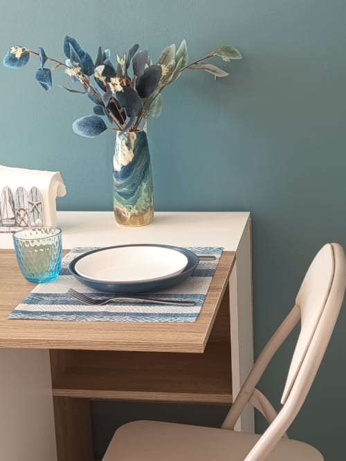 Elegantly set dining table at Pugetvilla cottage with fresh flowers and place setting against teal wall