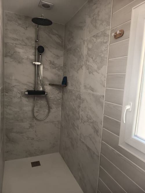 Modern walk-in shower with marble-effect tiling and rainfall showerhead at Pugetvilla cottage in Puget-Ville