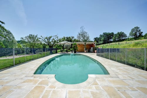 Piscine turquoise avec terrasse en pierre au Domaine Bellavigne Gîtes et Spa à Forcalquier, entourée de la campagne