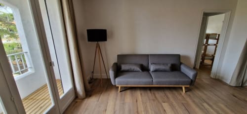 Séjour moderne de l'appartement O SOLEIL à Saint-Cyr-sur-Mer avec canapé gris, parquet, téléviseur et vue sur le jardin