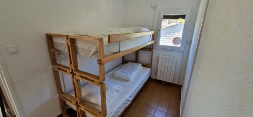 Lits superposés en bois avec draps blancs dans une chambre lumineuse aux Terrasses des Lecques à Saint-Cyr-sur-Mer
