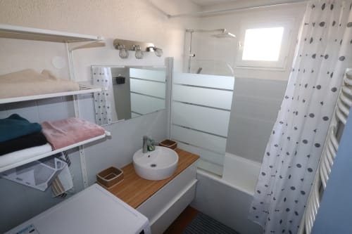 Salle de bain moderne de l'appartement O SOLEIL aux Terrasses des Lecques, Saint-Cyr-sur-Mer avec carrelage blanc, meuble vasque en bois et douche