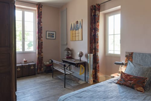 Chambre lumineuse au gîte Le Clos Saint Maurin à Saint Maurin, France, avec espace bureau et rideaux colorés