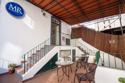 Terraço do hotel Madeirarooms em Funchal com área de estar, escadas e cobertura