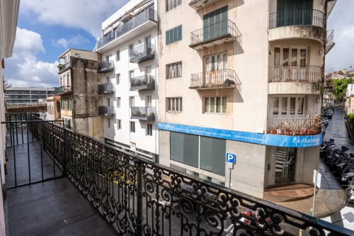 Varanda do hotel Madeirarooms com vista para a rua de Funchal, edifícios históricos e fachada azul