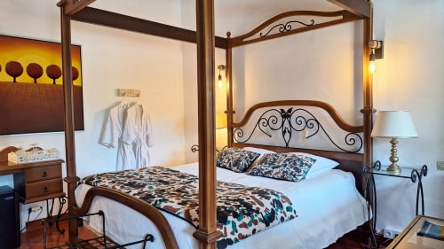 Chambre de lune de miel élégante avec lit à baldaquin en bois à La Bergerie Du Moulin, Taradeau, vue piscine depuis balcon
