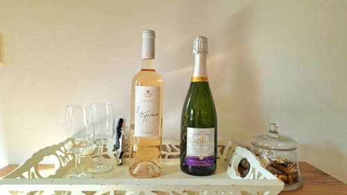 Bouteilles de rosé et champagne avec verres sur plateau blanc à La Bergerie Du Moulin, Taradeau