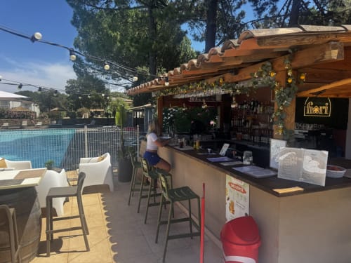 Bar en bord de piscine de l'hôtel Tamaricciu Di Cala Rossa à Lecci avec pergola en bois, sièges et piscine