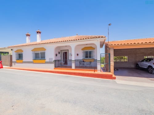 Villa blanca con acentos naranjas y tejado de barro en Alhaurín Loft City Center, con cochera y entrada