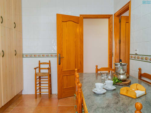 Cocina rústica española con muebles de madera, azulejos de terracota y decoración tradicional en la villa Alhaurín Loft City Center