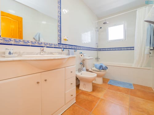 Baño moderno en Alhaurín Loft con tocador melocotón, acentos de azulejos azules, ducha, bidé y baldosas de terracota