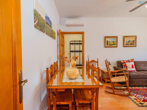 Cálida mesa de comedor de madera con sillas en villa Riad de Maruchi, pisos de barro y decoración rústica