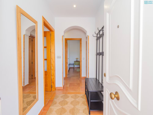 Pasillo moderno con puertas de madera y suelo de barro en la villa Riad de Maruchi de Alhaurín Loft City Center, España