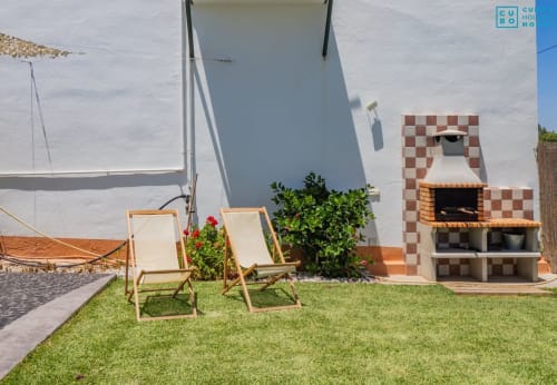 Villa Riad de Maruchi en Alhaurín Loft con tumbonas en el césped, paredes encaladas y chimenea exterior