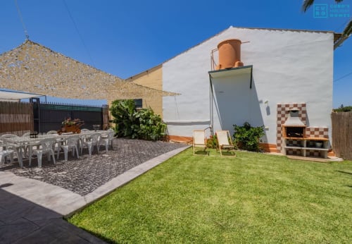 Villa loft Alhaurín con jardín manicurado, parrilla de ladrillo, tanque de agua blanco y área de estar al aire libre