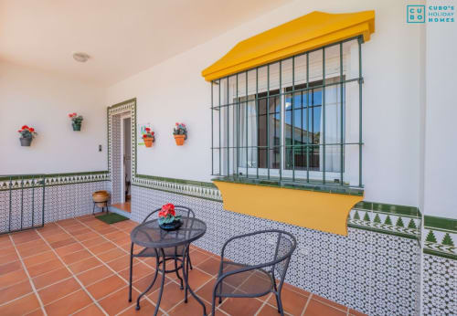Terraza del Riad de Maruchi en Alhaurín con toldo amarillo, azulejos decorativos y zona de estar