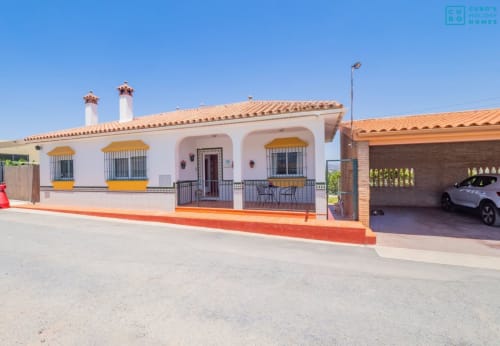 Villa Loft de Alhaurín con muros blancos, techo de barro, toldos amarillos y garaje en Alhaurín de la Torre