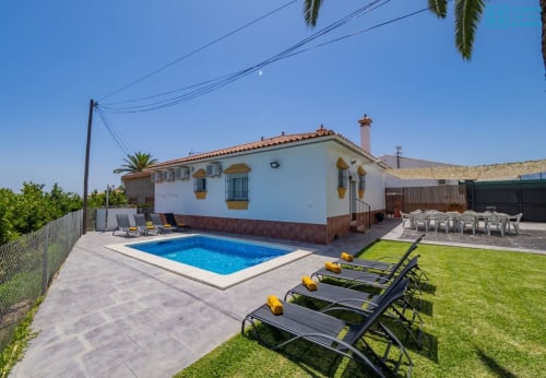 Villa Loft Alhaurín con piscina azul, tumbonas, jardín verde y casa blanca estilo andaluz en España