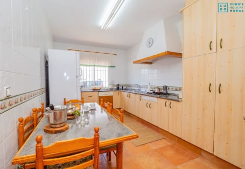 Cocina espaciosa con gabinetes de madera, mesa de comedor y electrodomésticos modernos en la villa Alhaurín Loft City Center
