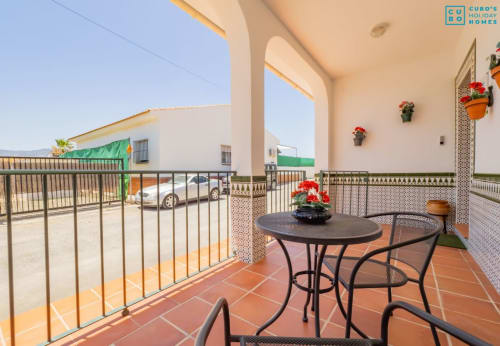 Terraza con mesa redonda, flores rojas y vistas a la piscina en Alhaurín Loft City Center