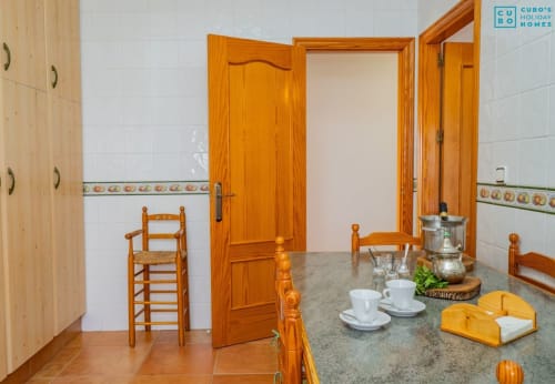 Cocina rústica con muebles de madera, encimera de granito, azulejos blancos y decoración española tradicional en Alhaurín Loft