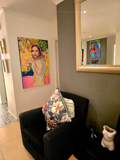 Modern apartment hallway with black wicker chair, colorful portrait artwork, and mirror in Stellenbosch guesthouse