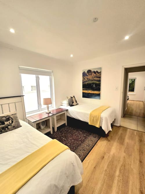 Modern bedroom in Art House apartment in Stellenbosch with two beds, mountain view, and wooden flooring