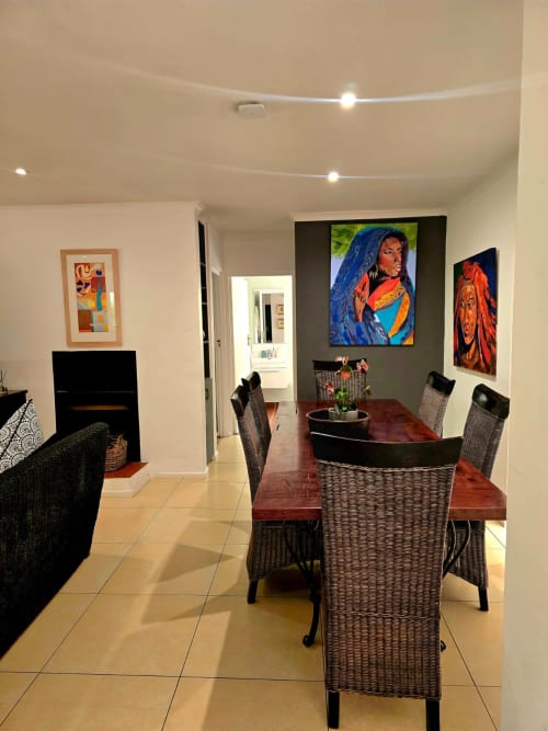 Modern dining area in Art House apartment in Stellenbosch with wicker chairs, artwork, and contemporary lighting